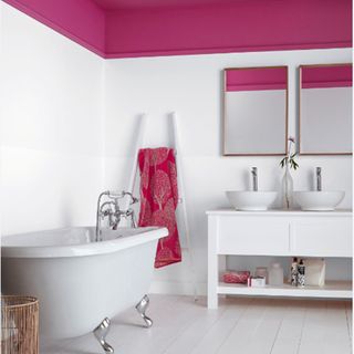 bathroom with white wall and pink ceiling and bathtub and ladder towel rack and washbasin