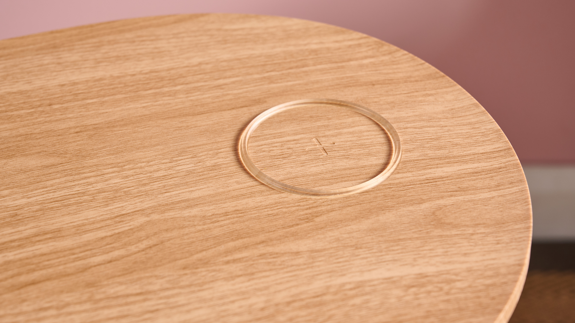 A close-up of the wireless Qi charger on the tabletop.