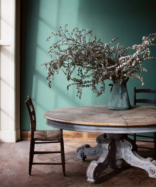 Dining room with green painted wall and wood table