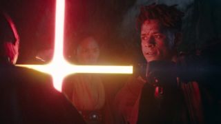 To protect someone, a man blocks the strike of a red lightsaber with their own green lightsaber.