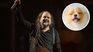 Jonathan Davis of Korn performing on stage next to image of puppy in circle
