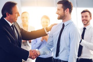 Photo of two men shaking hands in an office