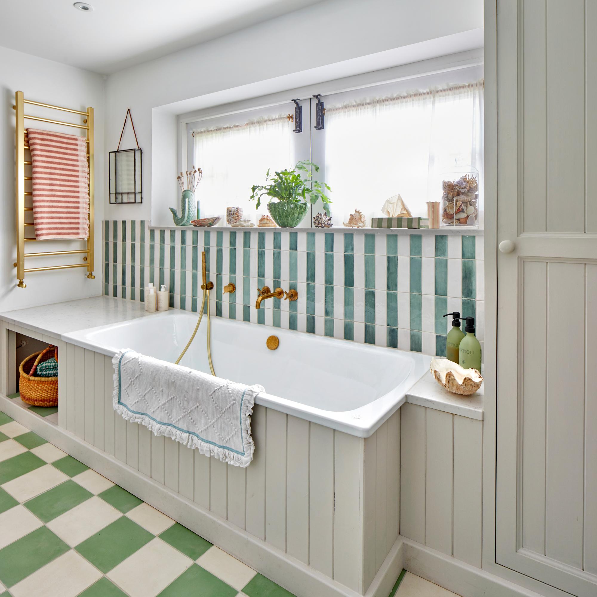 Green checkerboard tiled floor, built in whitebath with verticle blue stripe tile walls.