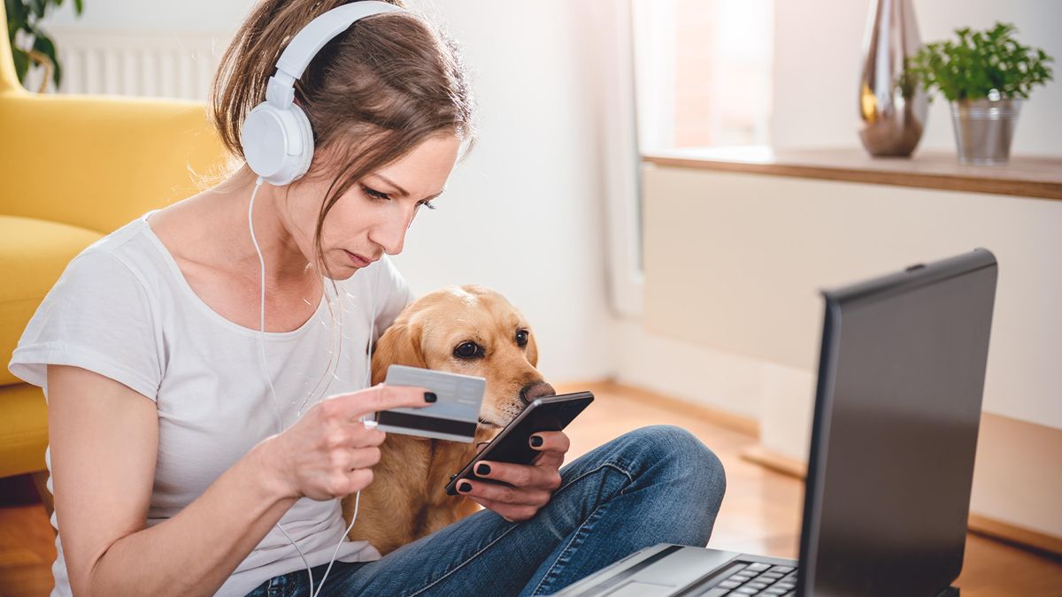 Woman experiencing cost of owning a dog – shopping online with dog in shot