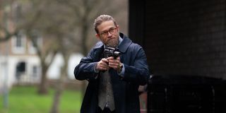 Ray (Charlie Hunnam) points a gun at an off-screen figure in 'The Gentlemen.'