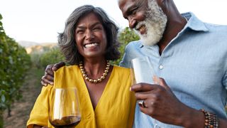 Couple laughing together holding a glass of wine