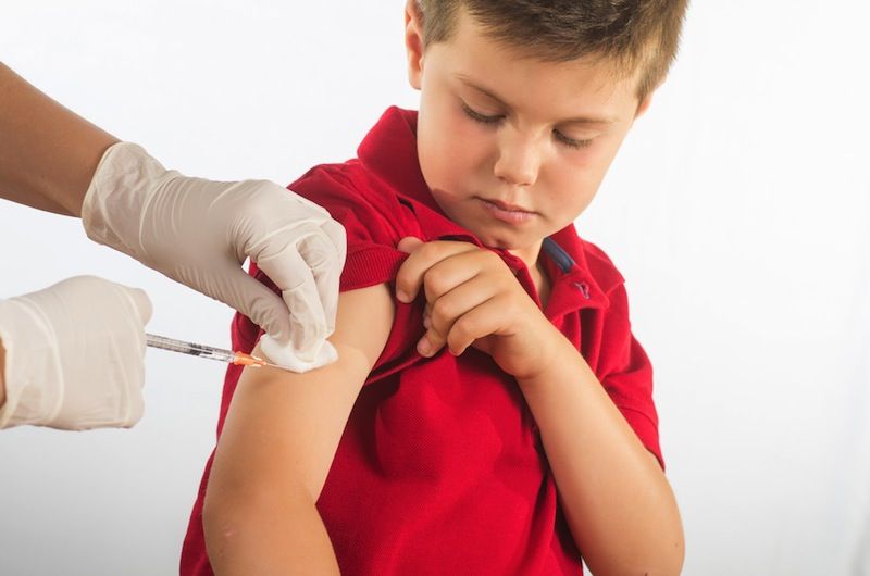 A young boy receives an injection at a doctor&#039;s visit.