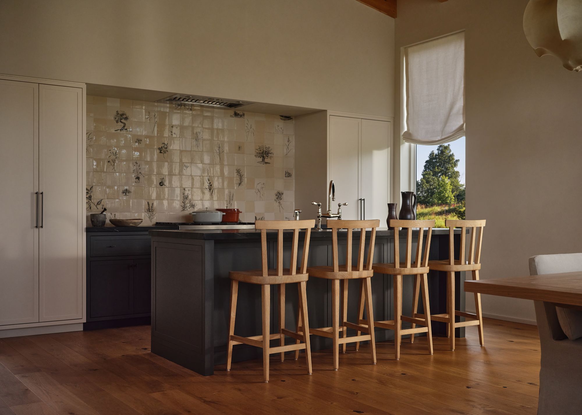 kitchen with a black island, four chairs, and white cabinetry