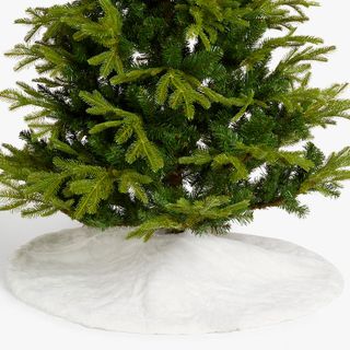 White faux fur tree skirt beneath green Christmas tree