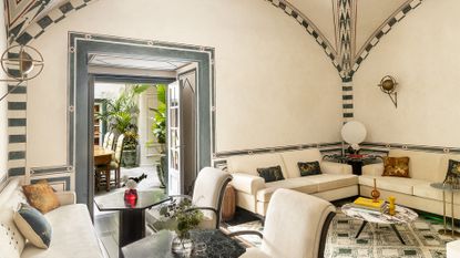 The Studiolo at The Place Firenze boasts an ample sitting area adorned with green and cream coloured fixtures, as well as a mosaic-style floor