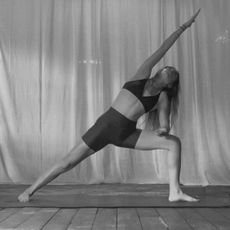 A woman doing yoga in a studio in shorts and a workout bra