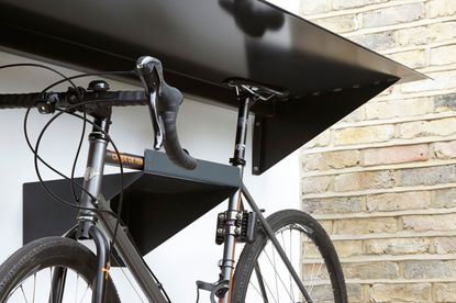 bike on a raised hook outside a home