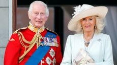 King Charles III, wearing his Irish Guards uniform, and Queen Camilla watch an RAF flypast from the balcony of Buckingham Palace after attending Trooping the Colour on June 15, 2024