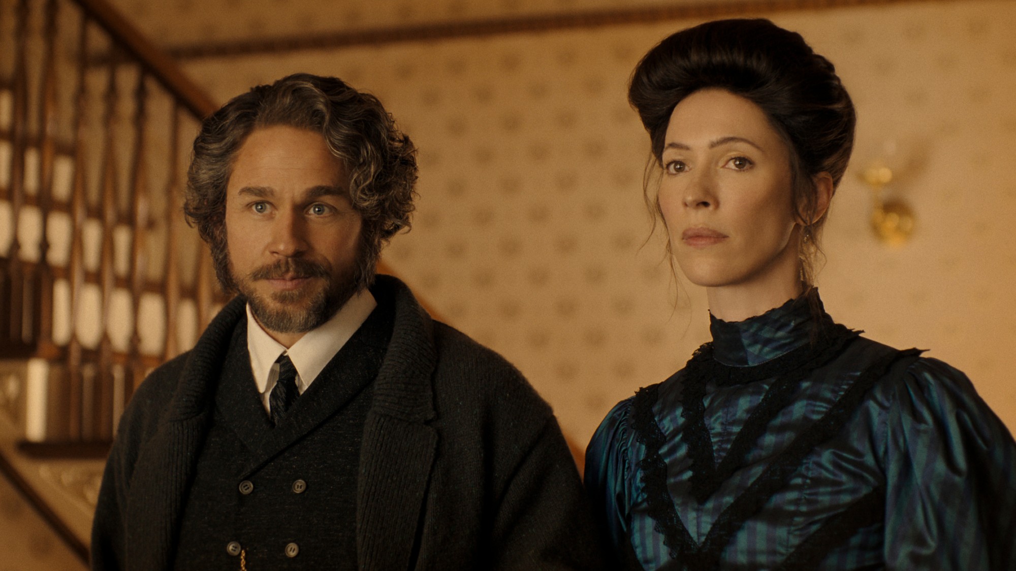 Mr. Borden and Mrs. Borden look at Maggie and Lizzie after suffering from their food-bourne illness. They both look unwell but displeased.