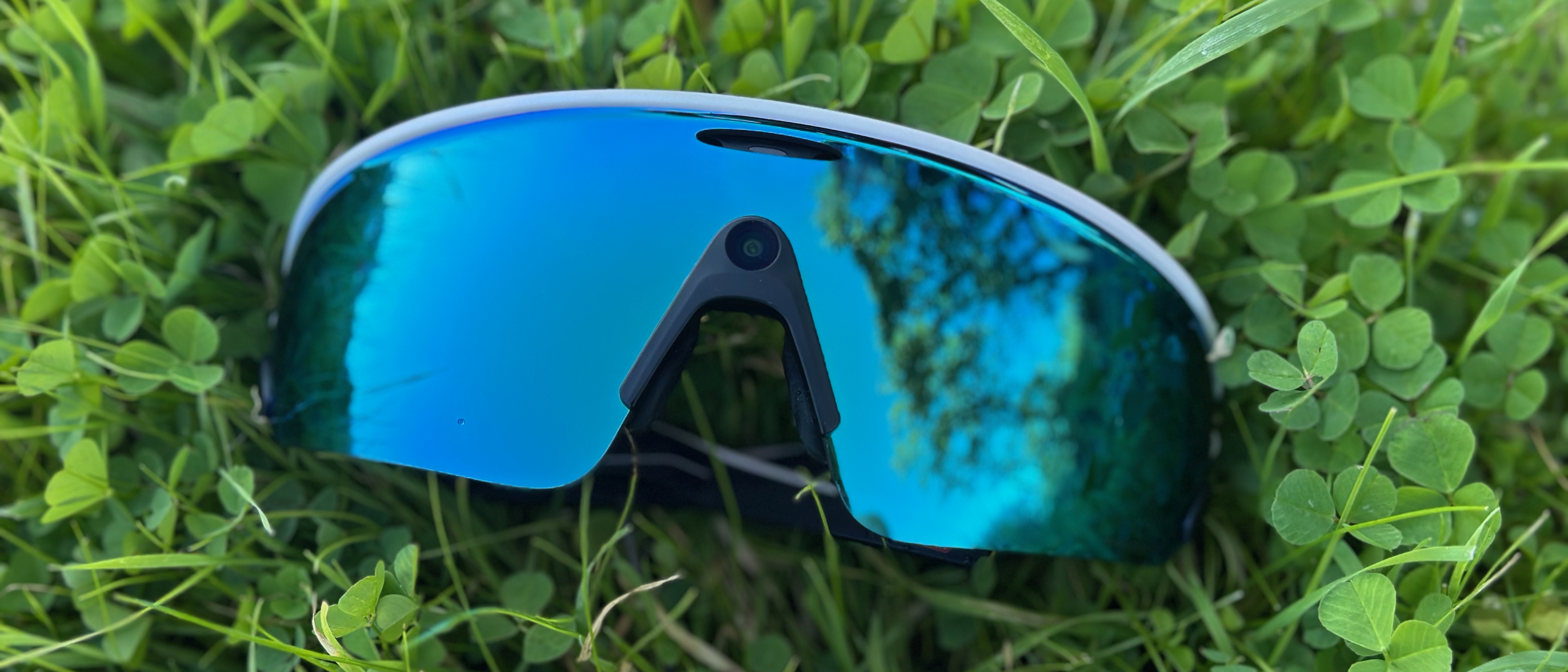 The Oakley Meta Vanguard smart glasses laying on grass.