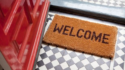 A welcome mat sits at an open front door.