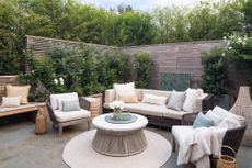 A backyard with seating accessorized with soft furnishing