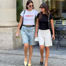 two women wearing long denim shorts with short-sleeve t-shirts