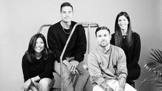 Two males and two females posing together sat down.