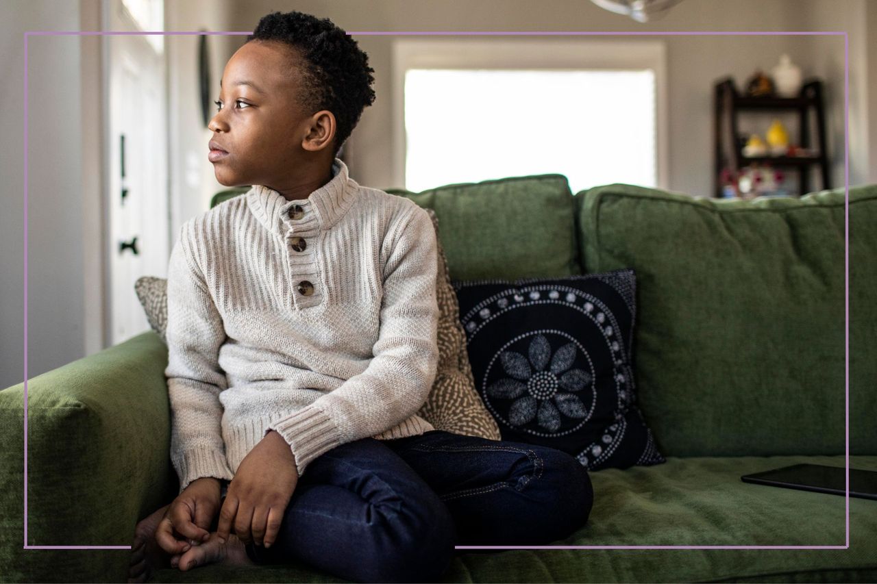 kid on sofa looking out window