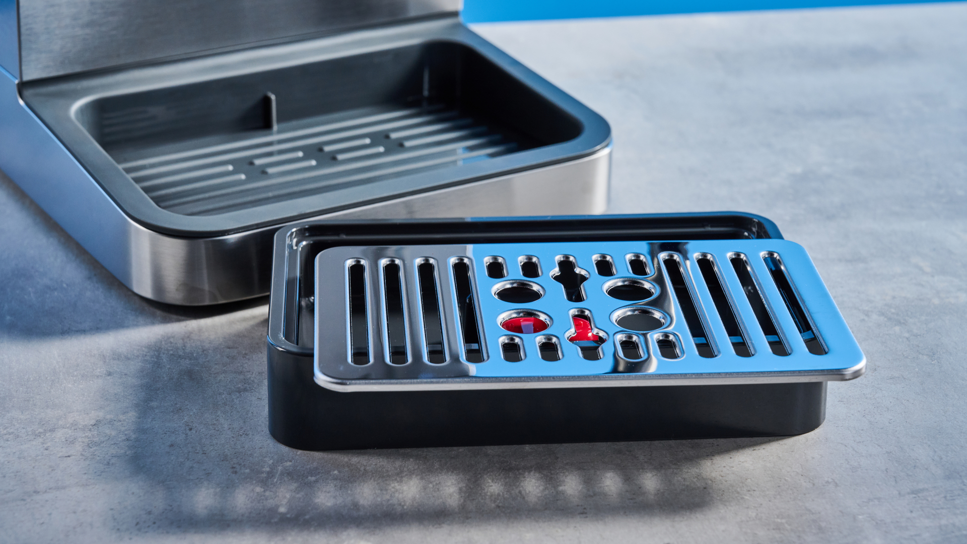 the De'Longhi Linea Classic espresso machine photographed against a blue tom's guide background, showing its silver finish, steam dial, steam wand, portafilter, and accessories