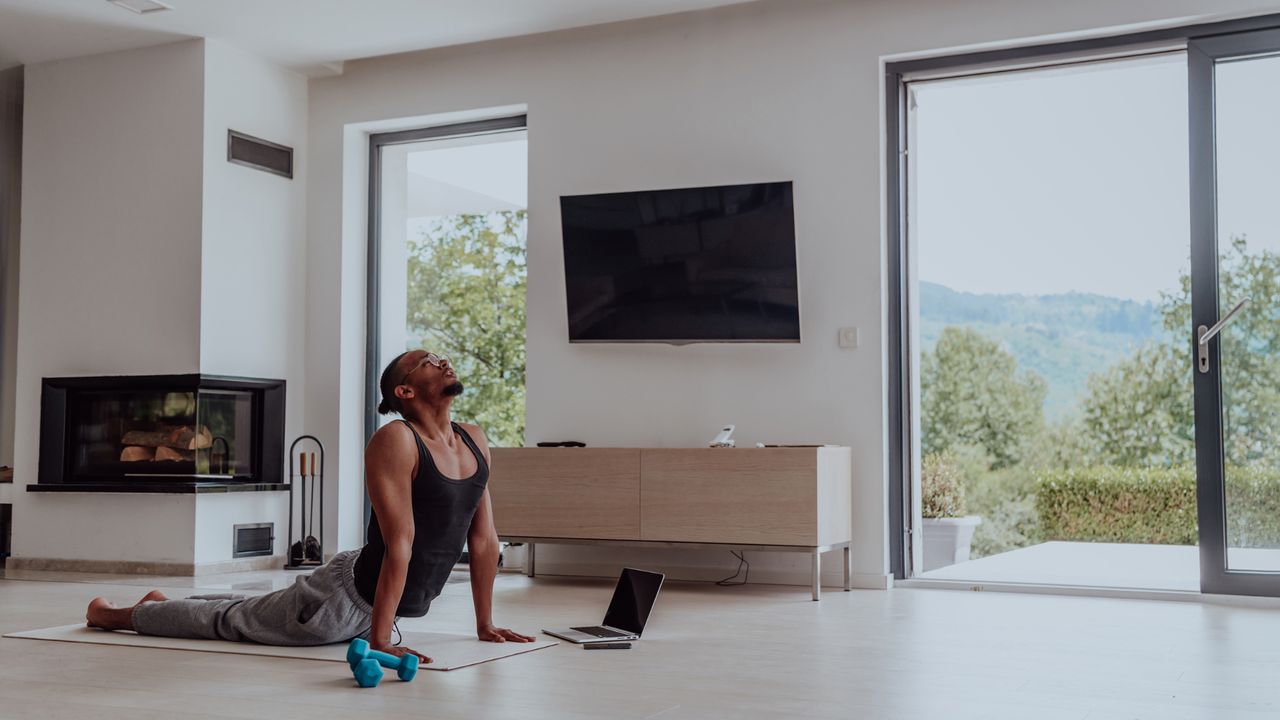 Man holding a cobra yoga pose at home