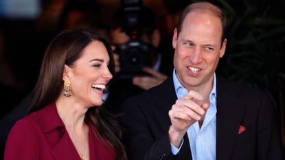 Kate Middleton wearing a red dress and laughing and Prince William laughing 