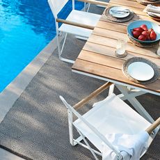 Table on rug next to pool