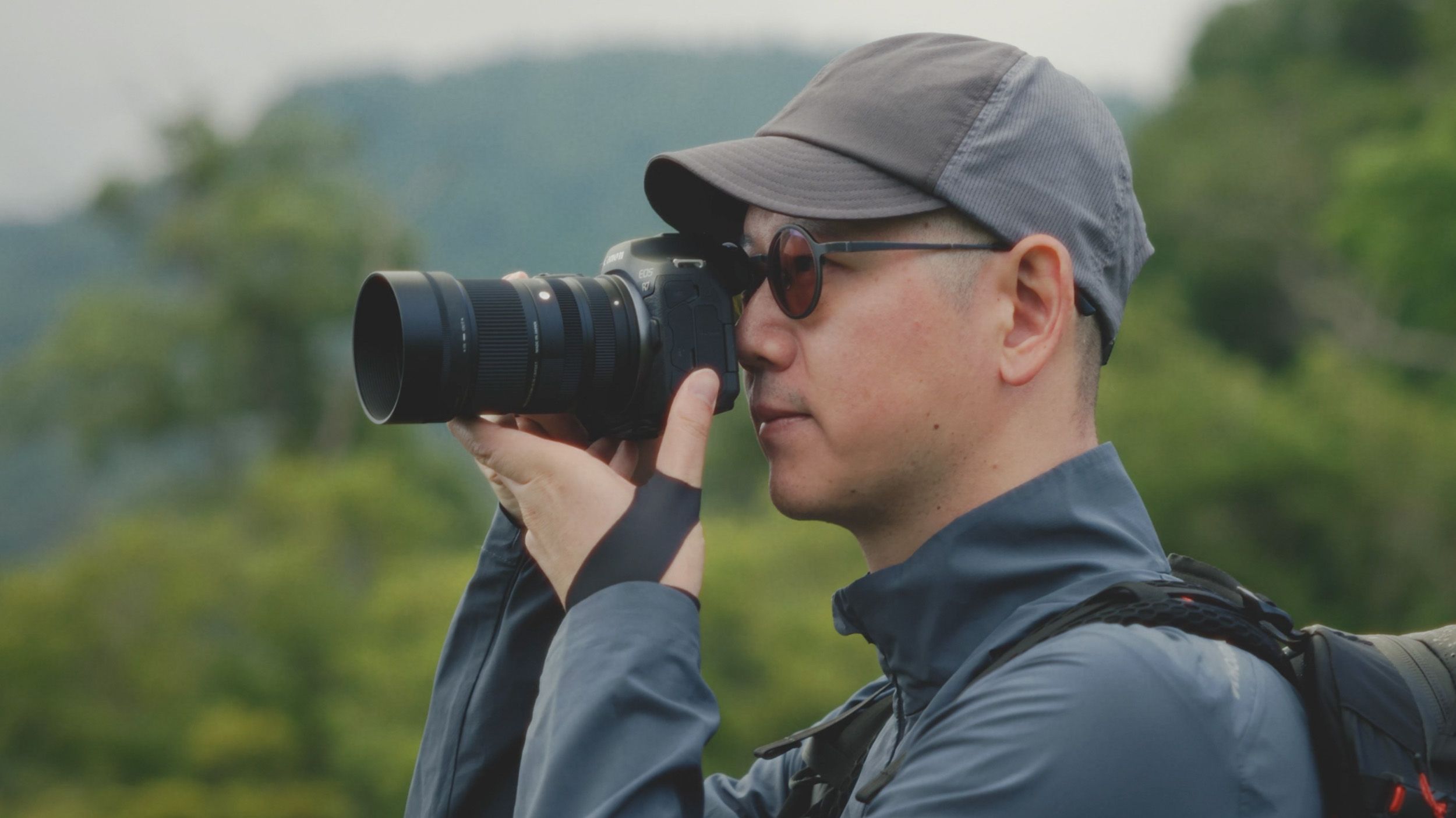 Sigma 50-120mm F2.8 DC OS Contemporary lens attached to a Canon camera, held by a photographer outdoors