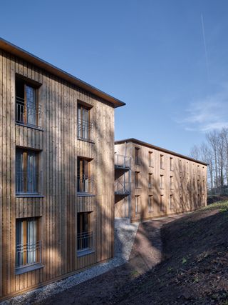 Refugee housing by Stocker Dewes Architekten. A three storey housing project with wooden walls.