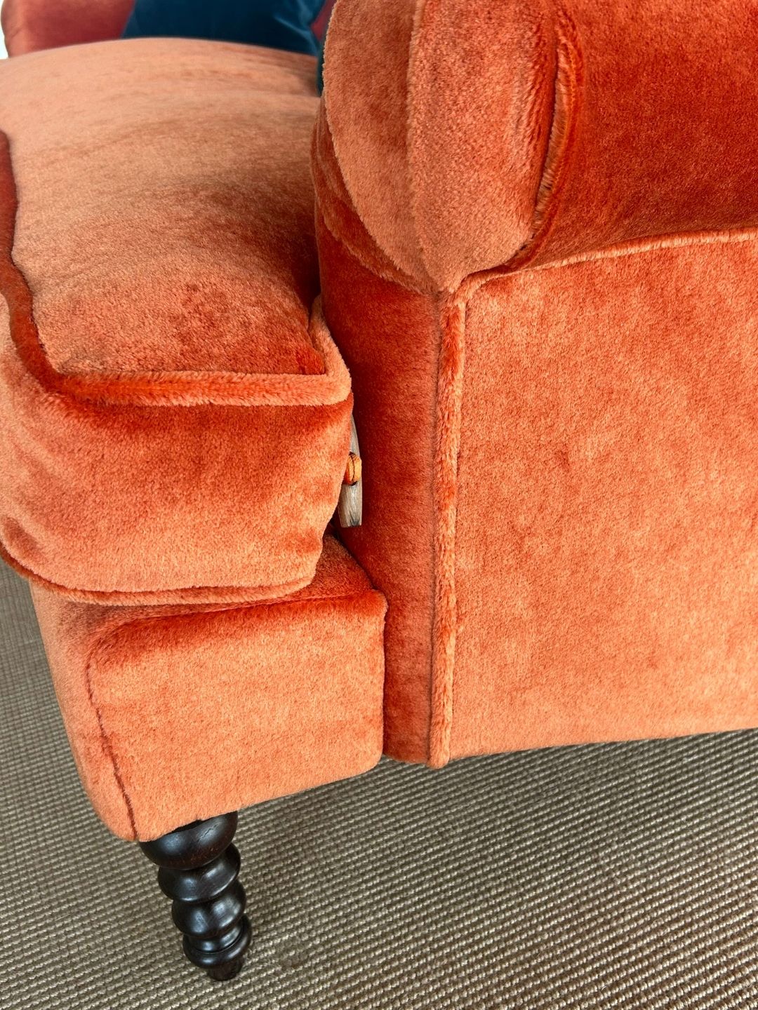 Highlighting the button fastening that secures the bench seat cushion to the frame, alongside its upholstery.