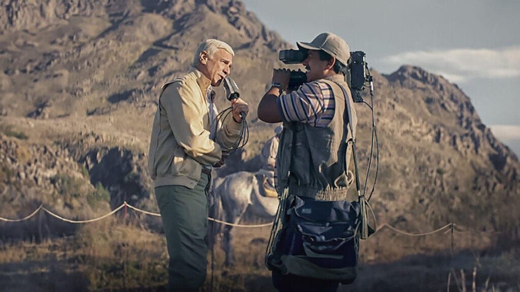 A journalist and his cameraman film in the rugged mountains