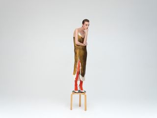 Woman in Prada dress standing on stool