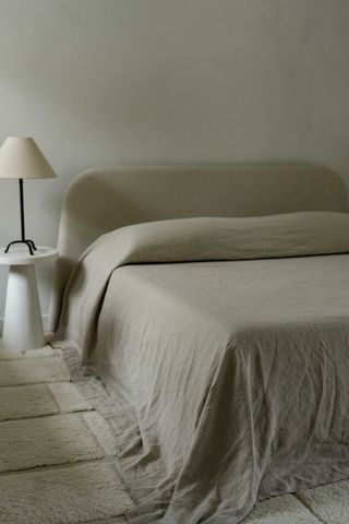 a bed styled with a coverlet draped over