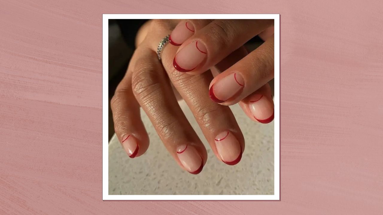 A close-up of hands with short, dark red French tip nails by nail artist Mateja Novakovic (@matejanova)/ in a muted, dark pink template