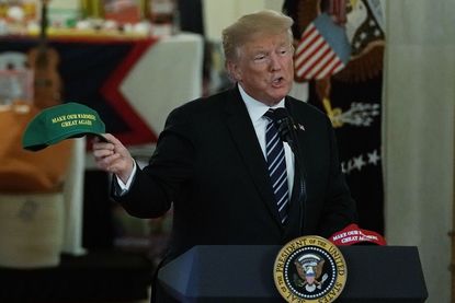 Trump holds a Make Our Farmers Great Again hat
