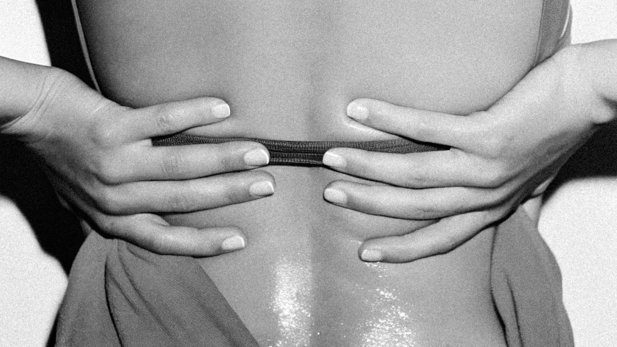 woman holding on to her back in black and white