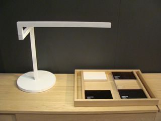 A square wood tray with two columns for business cards. A white stand with an arm.