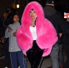 Nicki Minaj in a pink fur coat and yellow fur coat.