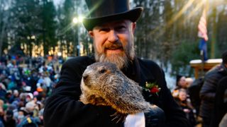 Groundhog handler AJ Derume holds Punxsutawney Phil, who saw his shadow, predicting a late spring during the 136th annual Groundhog Day festivities on Feb. 2, 2022 in Punxsutawney, Pennsylvania.