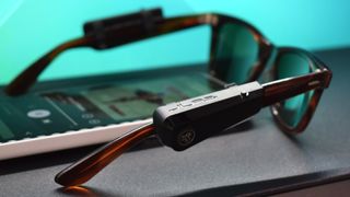 JLab JBuds Frames photograph showing devices on Ray-Ban sunglasses playing audio over Bluetooth from a smartphone