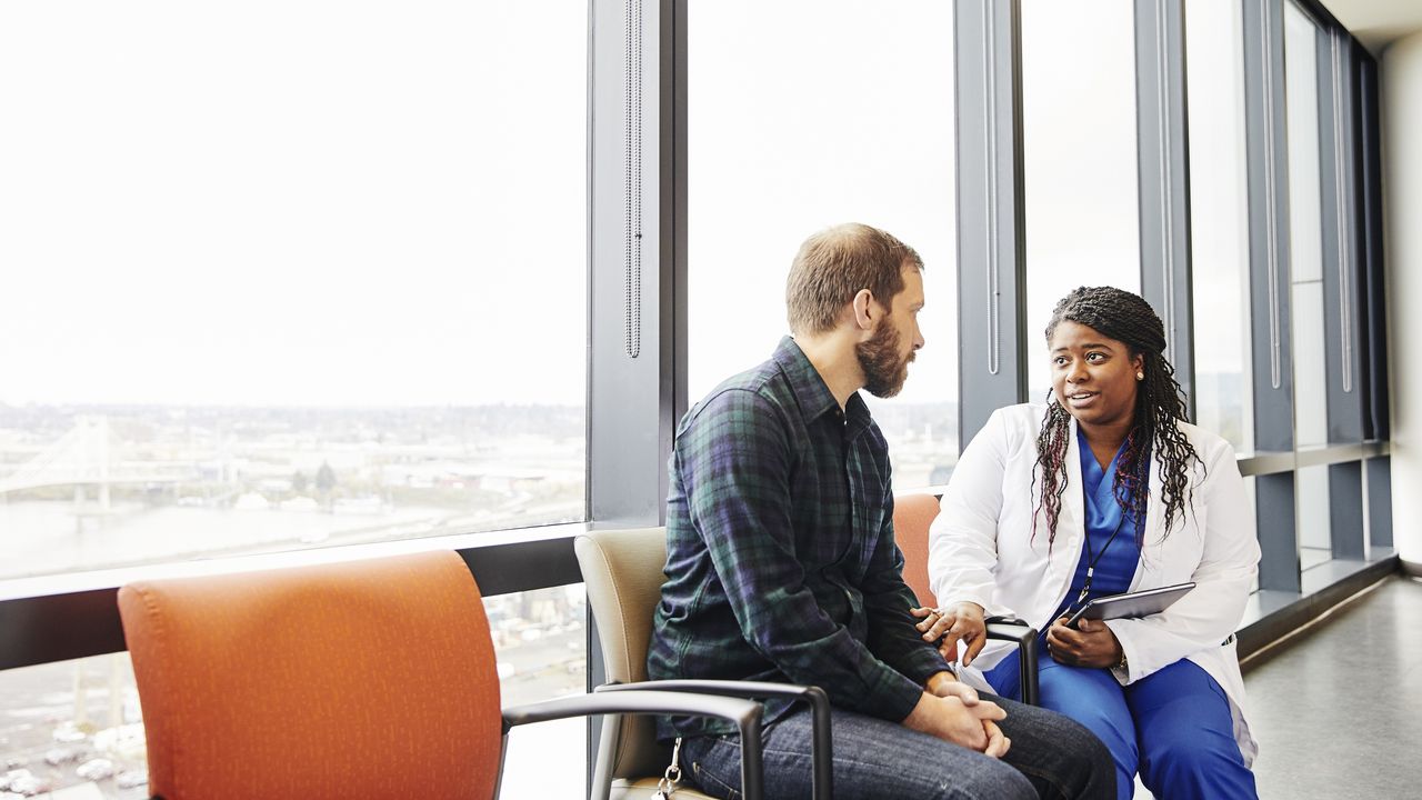 A doctor sits with a patient to give him advice.