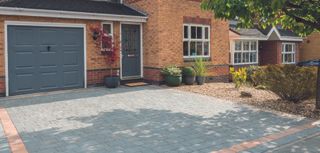driveway with block paving and gravel brightened by plants and pots
