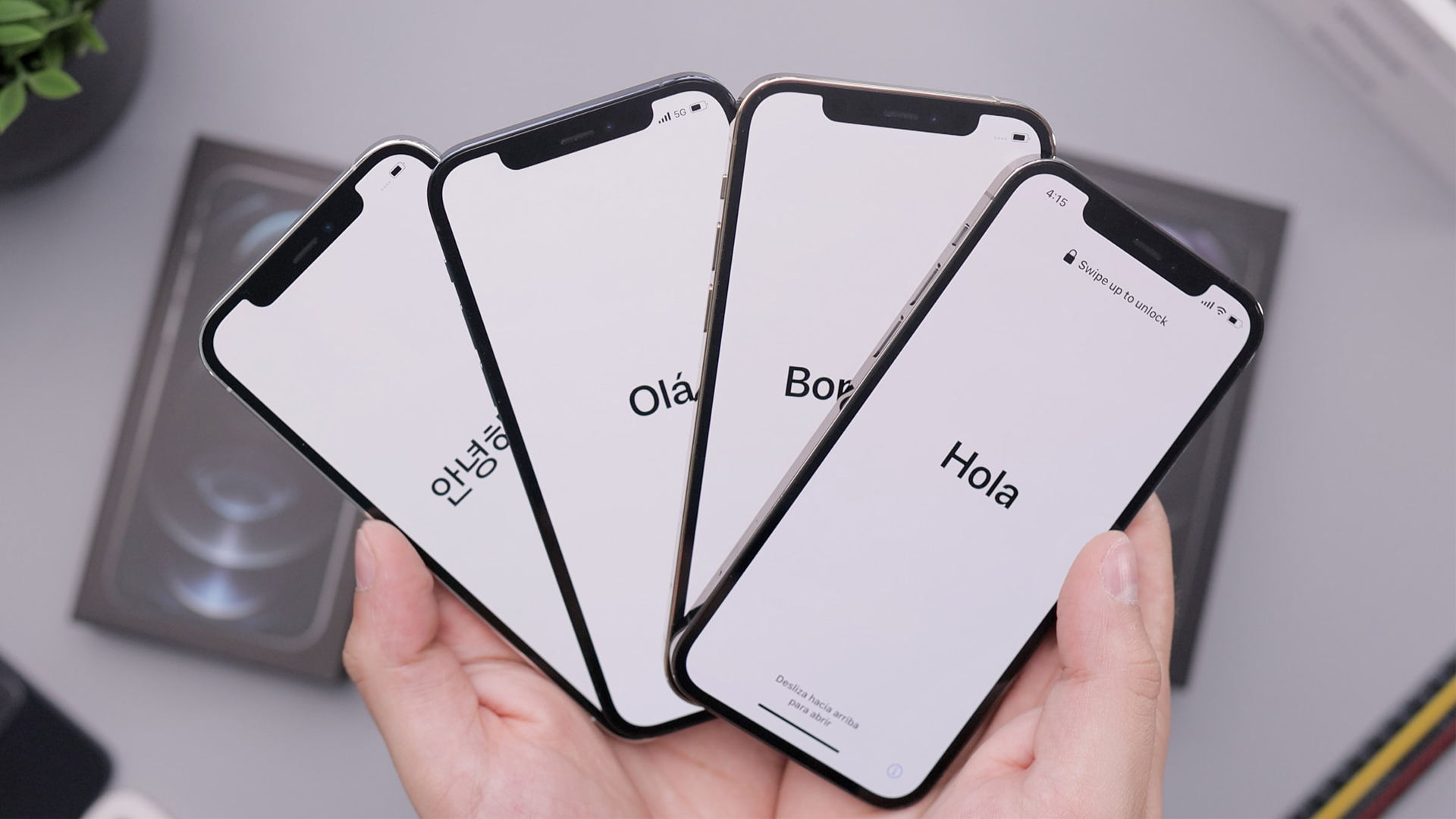 four iPhones in setup mode in someone's hands