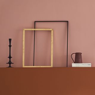Pink wall behind shelf with stylish items