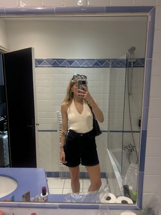 Eliza Huber wearing a Zara halter top with long Dissh denim shorts in a bathroom selfie in Nice.