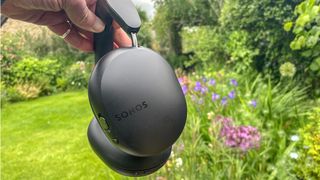 Sonos Ace headphone in black outside in the reviewer's garden