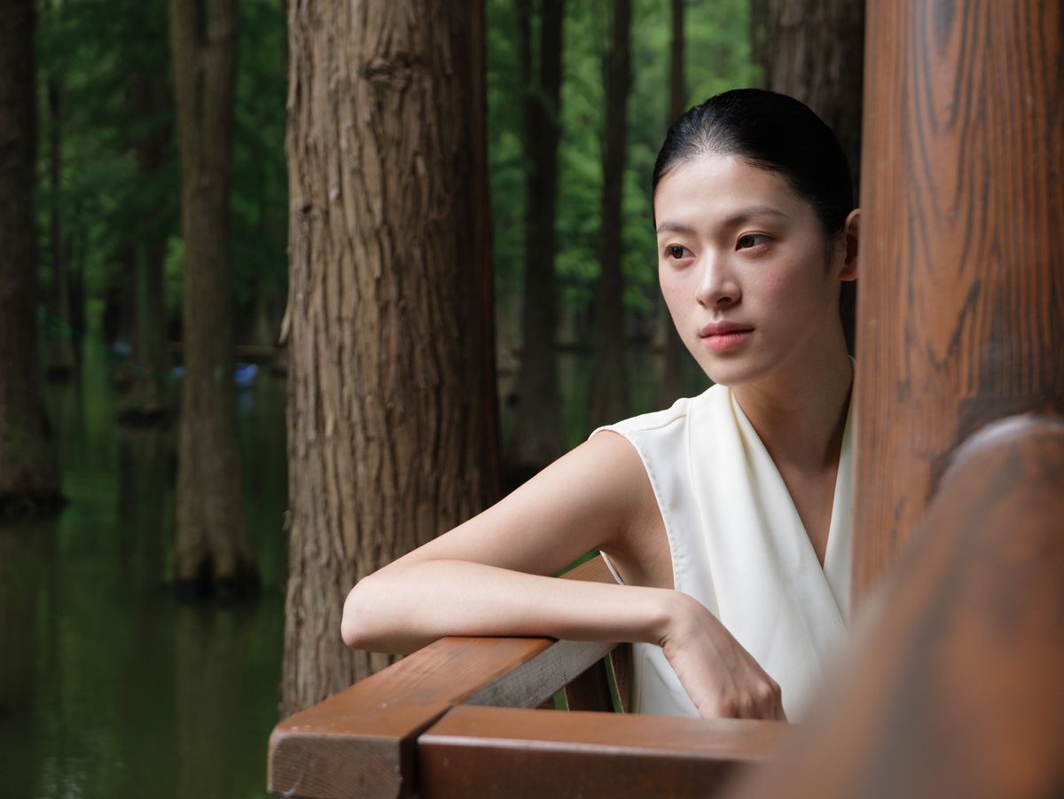 Panasonic Lumix L10 sample gallery: female model in white dress, leaning against a wooden barrier in a nature reserve