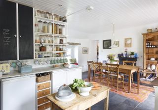 open-plan kitchen diner in with glass jars on open shelving as a storage idea