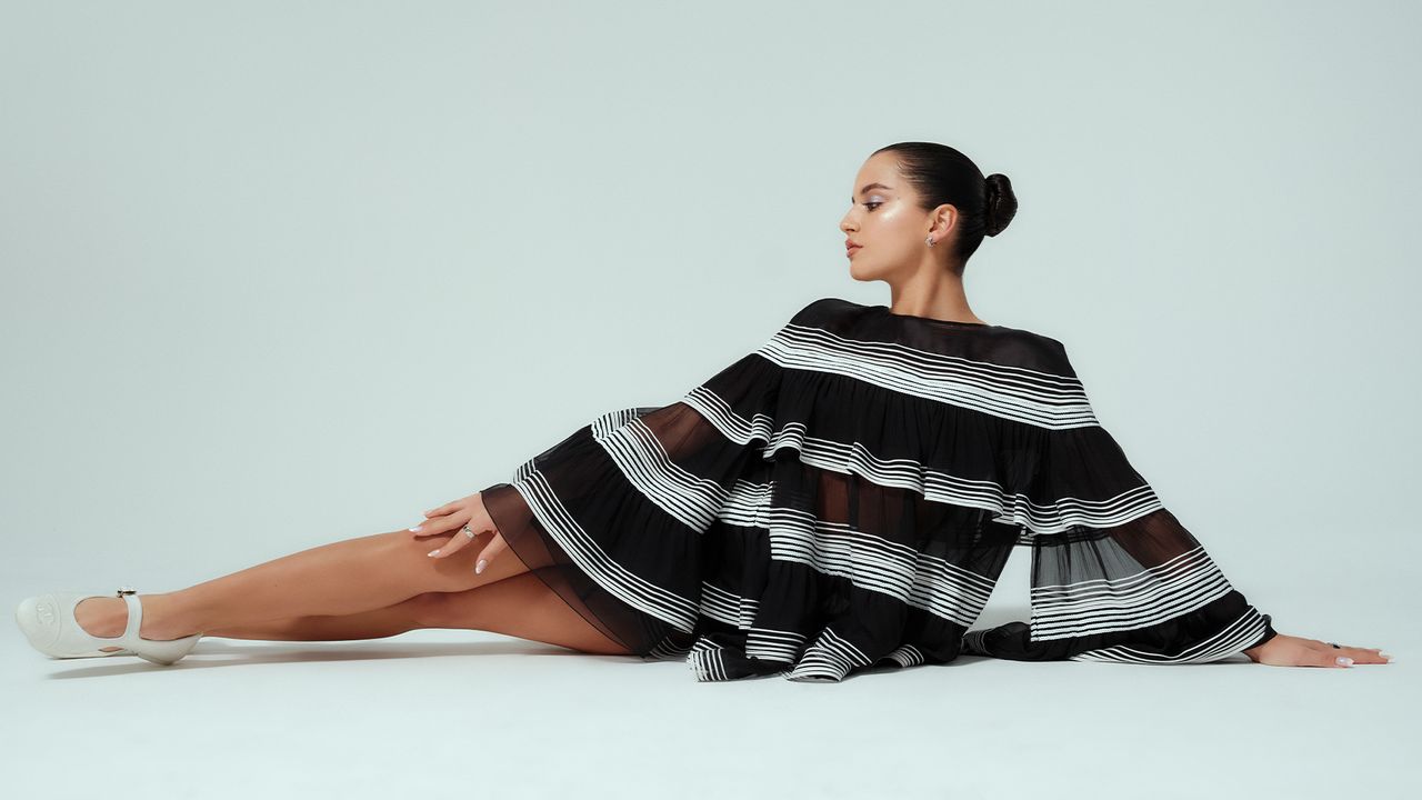 Isabela Merced poses in Chanel black and white stripe dress. 